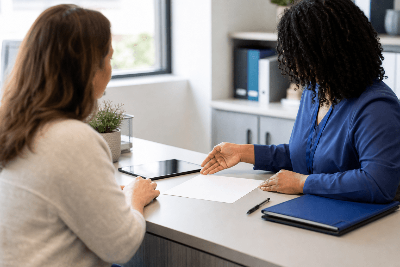 Patient and health information professional reviewing a blank medical records release process at a clinic desk